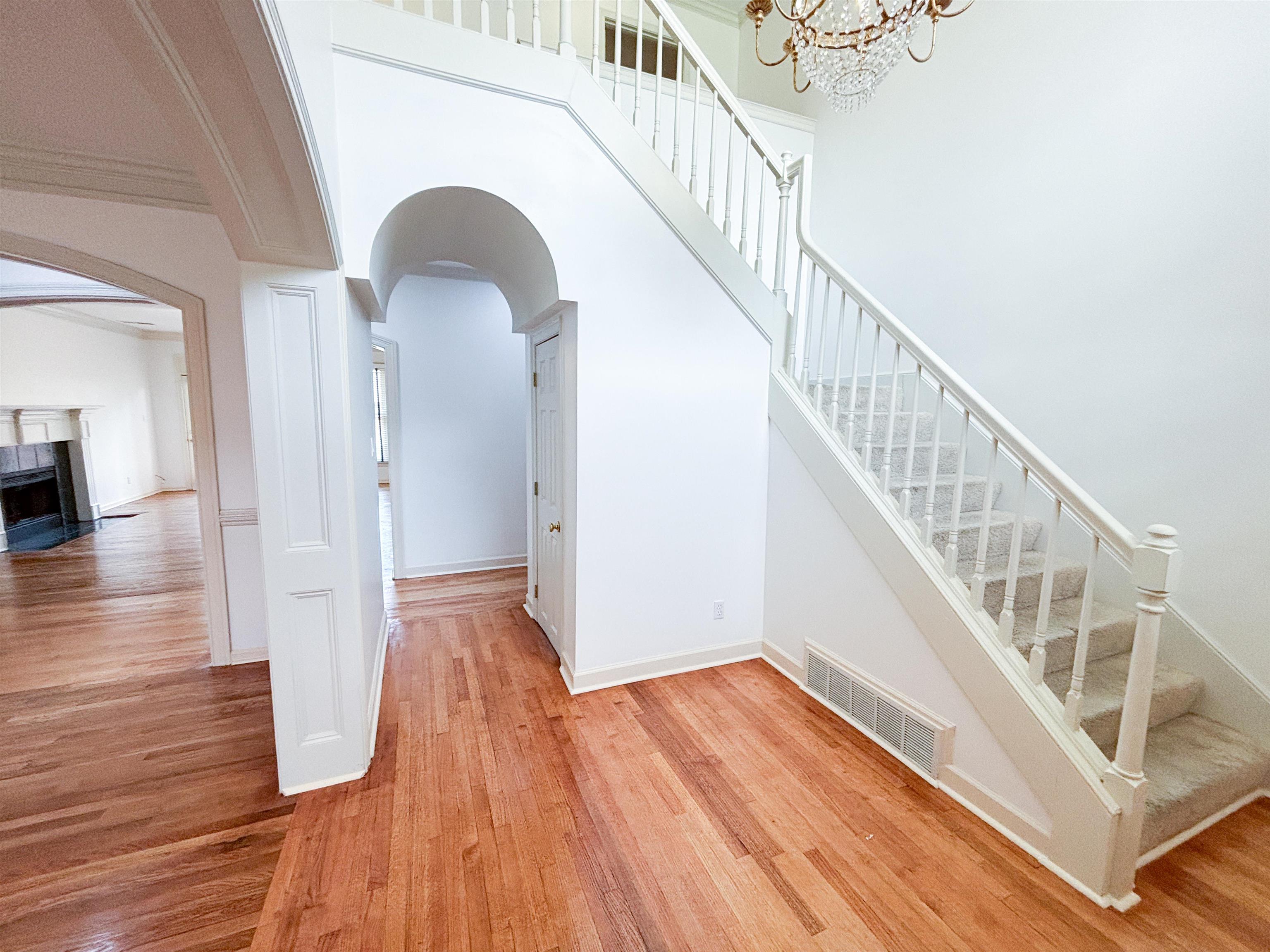 1923 Swynford Lane Collierville, TN 38017 - Photo 4 of 35 Stairs featuring arched walkways, wood finished floors, a fireplace, and a high ceiling