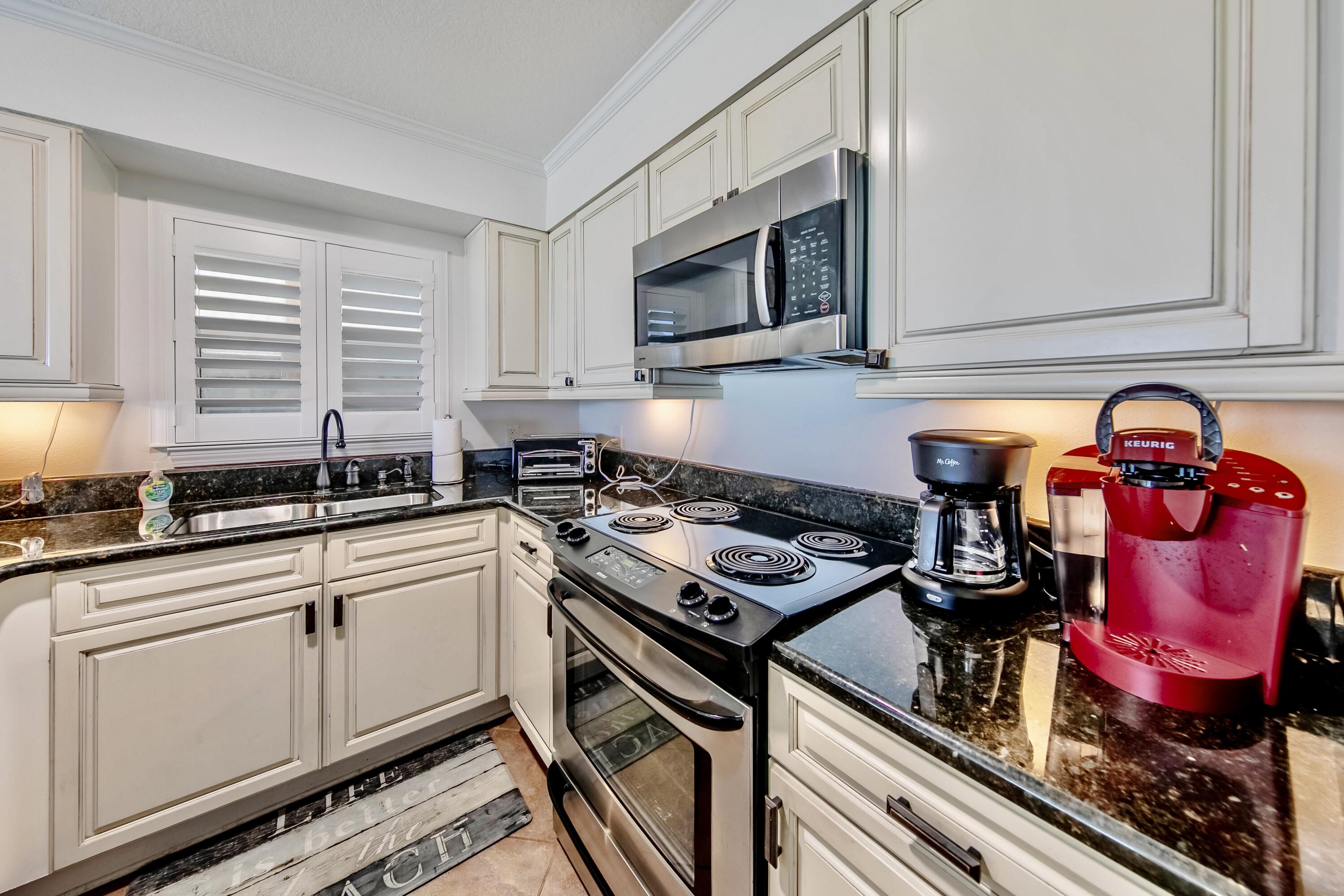 595 Eastern Lake Road, Unit 103 Santa Rosa Beach, FL 32459 - Photo 24 of 30 a kitchen with stainless steel appliances granite countertop a stove and a microwave