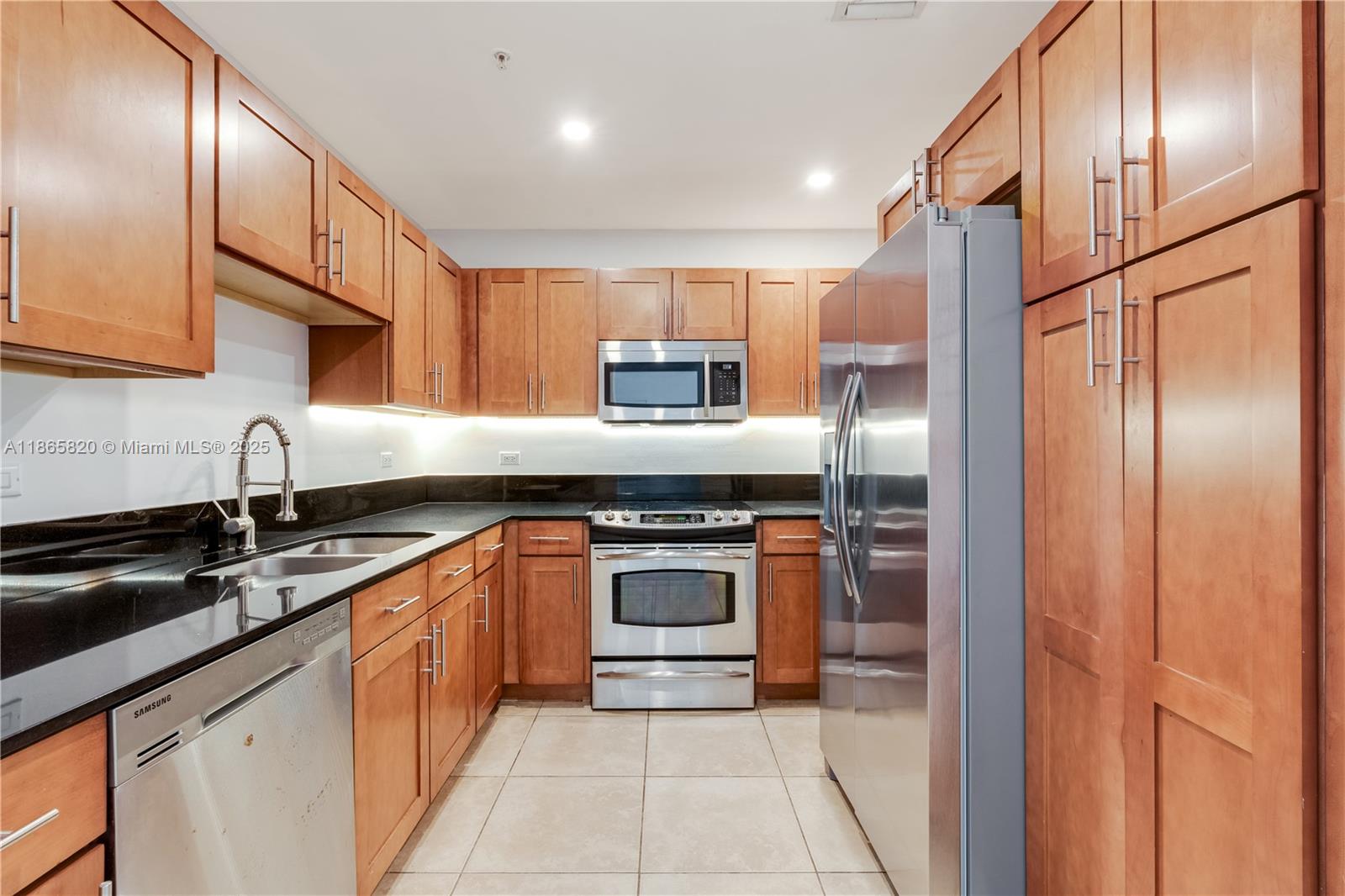 8395 Southwest 73rd Avenue, Unit 517 Miami, FL 33143 - Photo 5 of 27 a kitchen with stainless steel appliances granite countertop a refrigerator a sink a stove and oven