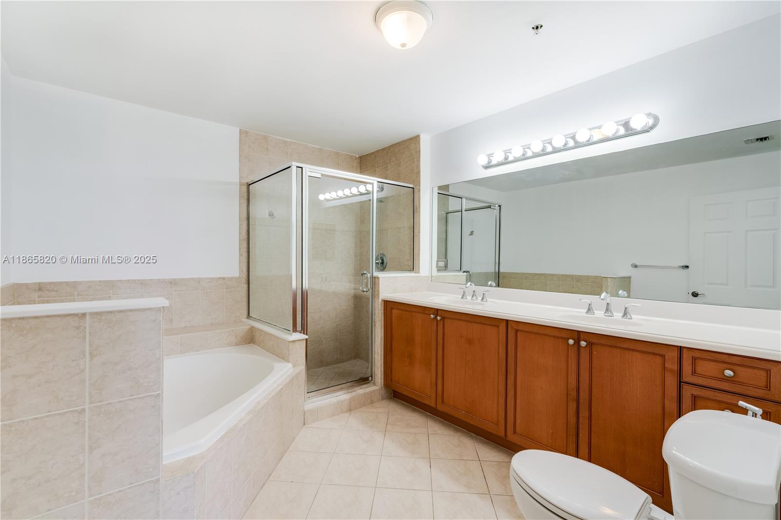 8395 Southwest 73rd Avenue, Unit 517 Miami, FL 33143 - Photo 6 of 27 a bathroom with a bathtub shower sink mirror vanity and toilet