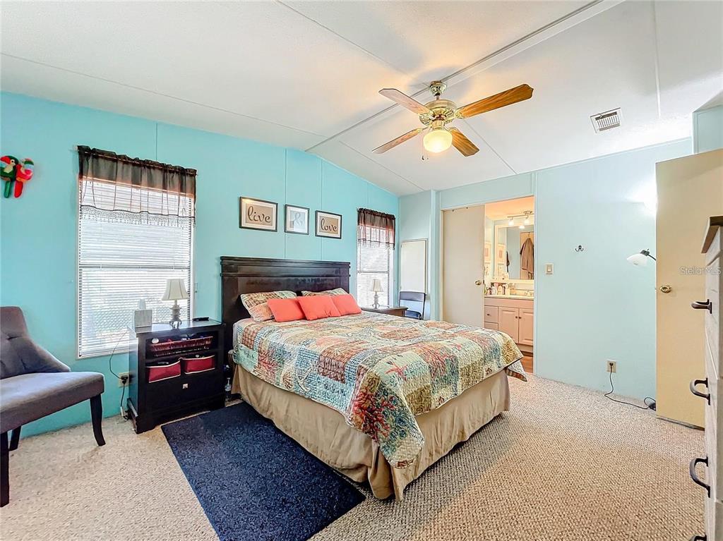 6 Cayman Circle Umatilla, FL 32784 - Photo 22 of 34 a bedroom with a bed a couch and a window