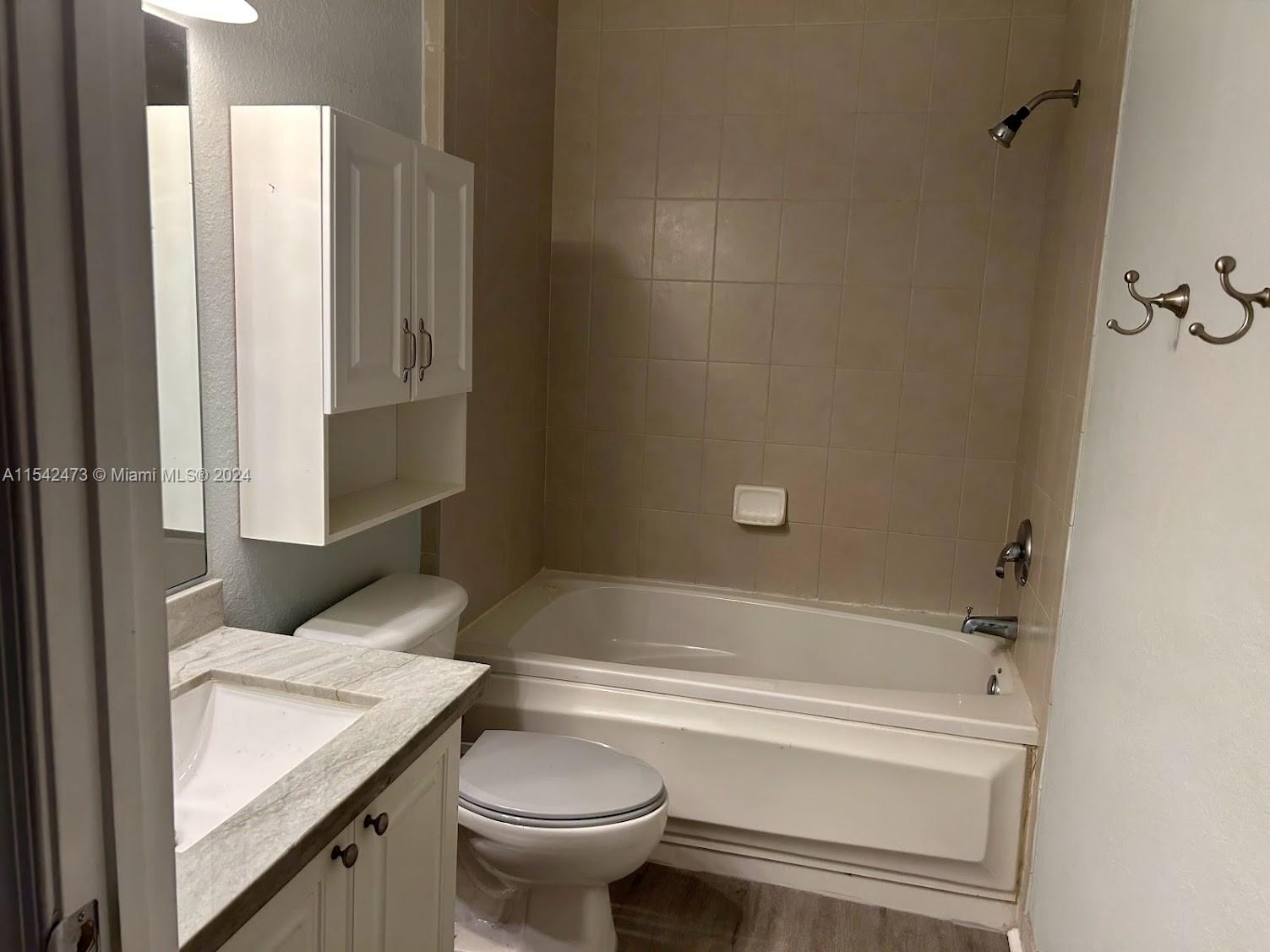 4802 Washington Street, Unit 5 Hollywood, FL 33021 - Photo 12 of 20 a bathroom with a granite countertop sink and a toilet