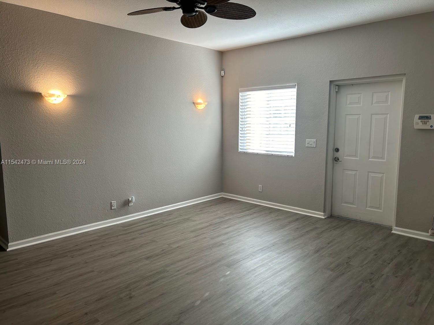 4802 Washington Street, Unit 5 Hollywood, FL 33021 - Photo 3 of 20 an empty room with wooden floor and windows