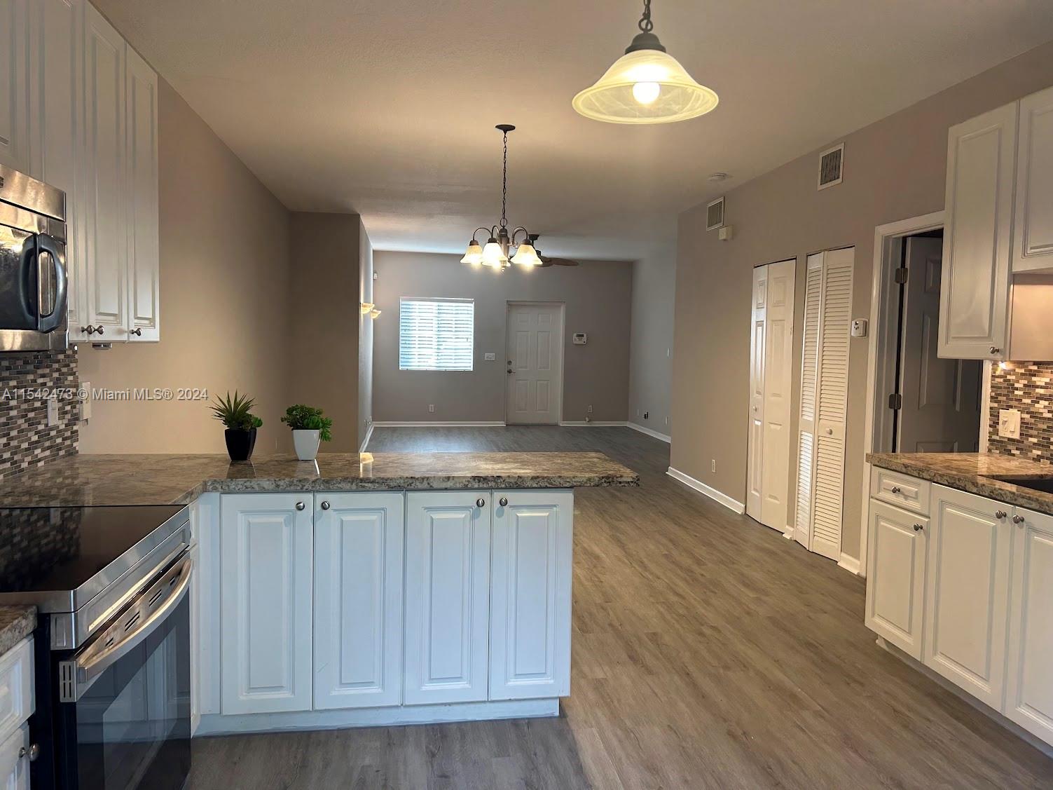4802 Washington Street, Unit 5 Hollywood, FL 33021 - Photo 4 of 20 a kitchen with kitchen island granite countertop a sink stainless steel appliances and cabinets
