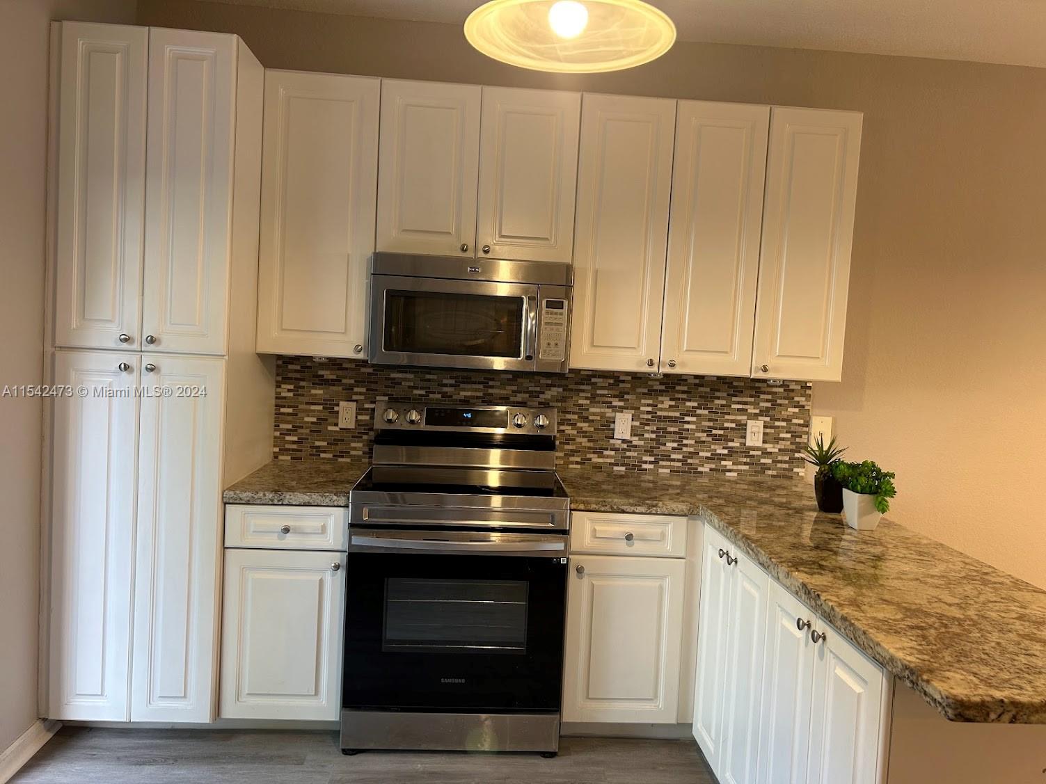 4802 Washington Street, Unit 5 Hollywood, FL 33021 - Photo 6 of 20 a kitchen with appliances a sink and cabinets