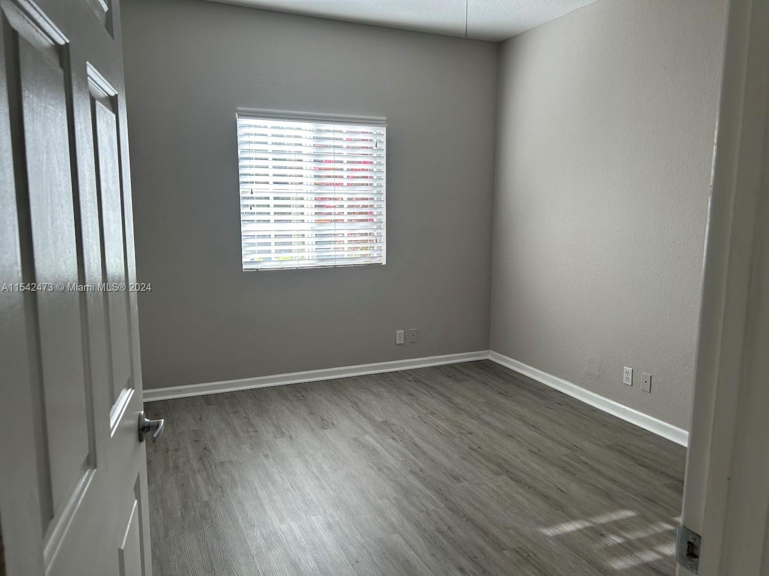 4802 Washington Street, Unit 5 Hollywood, FL 33021 - Photo 7 of 20 an empty room with wooden floor and windows