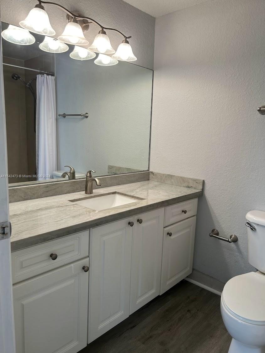 4802 Washington Street, Unit 5 Hollywood, FL 33021 - Photo 9 of 20 a bathroom with a granite countertop toilet sink and mirror