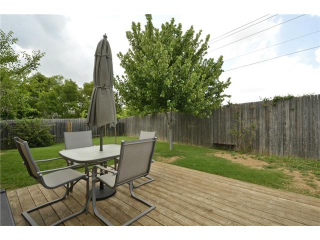 11612 Timber Heights Drive Austin, TX 78754 - Photo 21 of 28 A spacious wood deck offers an ideal spot for outdoor gatherings, bordered by a privacy fence and lush greenery.