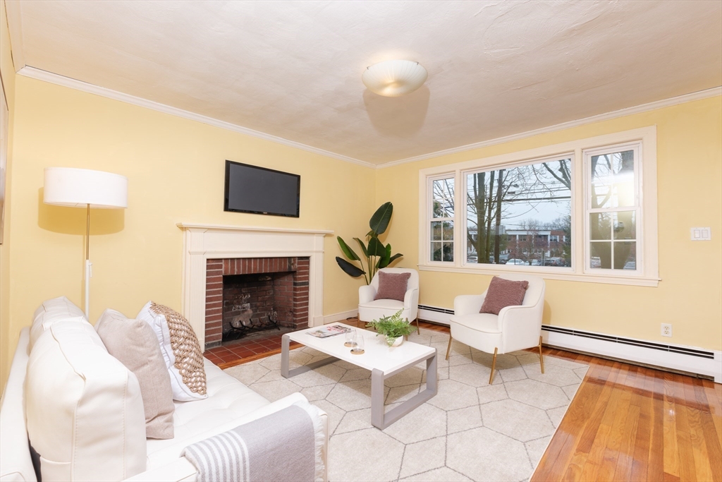 2096 Washington Street Newton, MA 02468 - Photo 4 of 13 a living room with furniture a flat screen tv and a fireplace