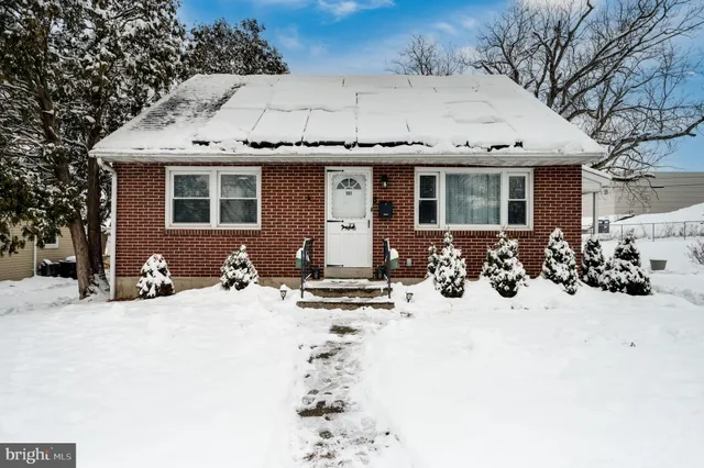 a view of a house with snow on the side of the road
