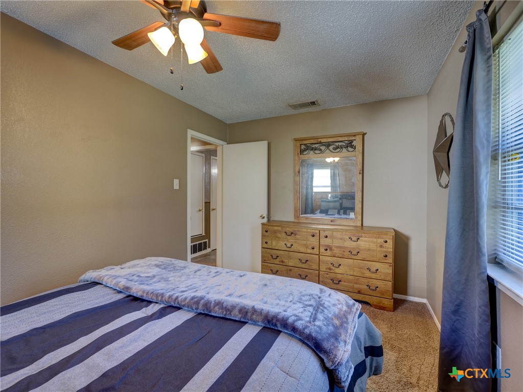 103 Lackey Street Florence, TX 76527 - Photo 17 of 39 a bedroom with a bed dresser and a window