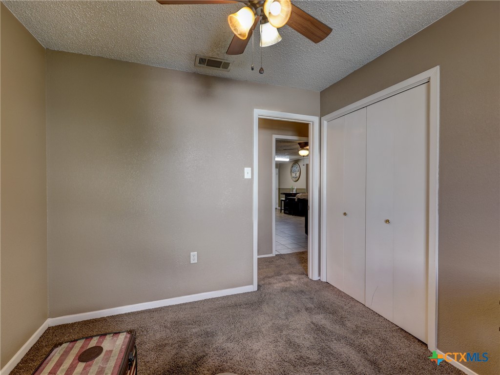 103 Lackey Street Florence, TX 76527 - Photo 20 of 39 a view of an empty room and a chandelier fan