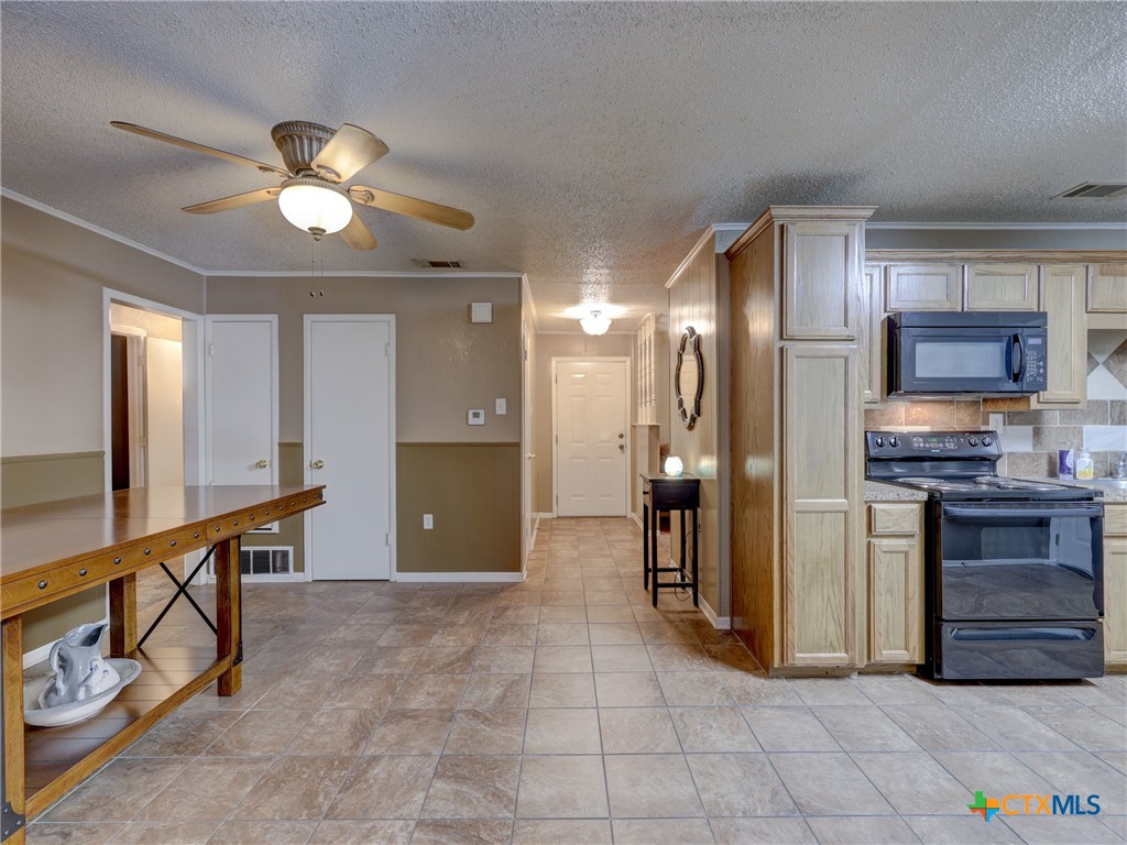 103 Lackey Street Florence, TX 76527 - Photo 31 of 39 a large kitchen with cabinets and stainless steel appliances