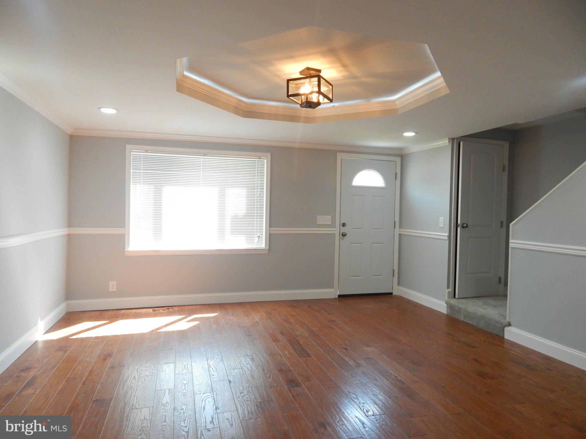 5618 Clearspring Road Baltimore, MD 21212 - Photo 2 of 30 an empty room with wooden floor fan and windows