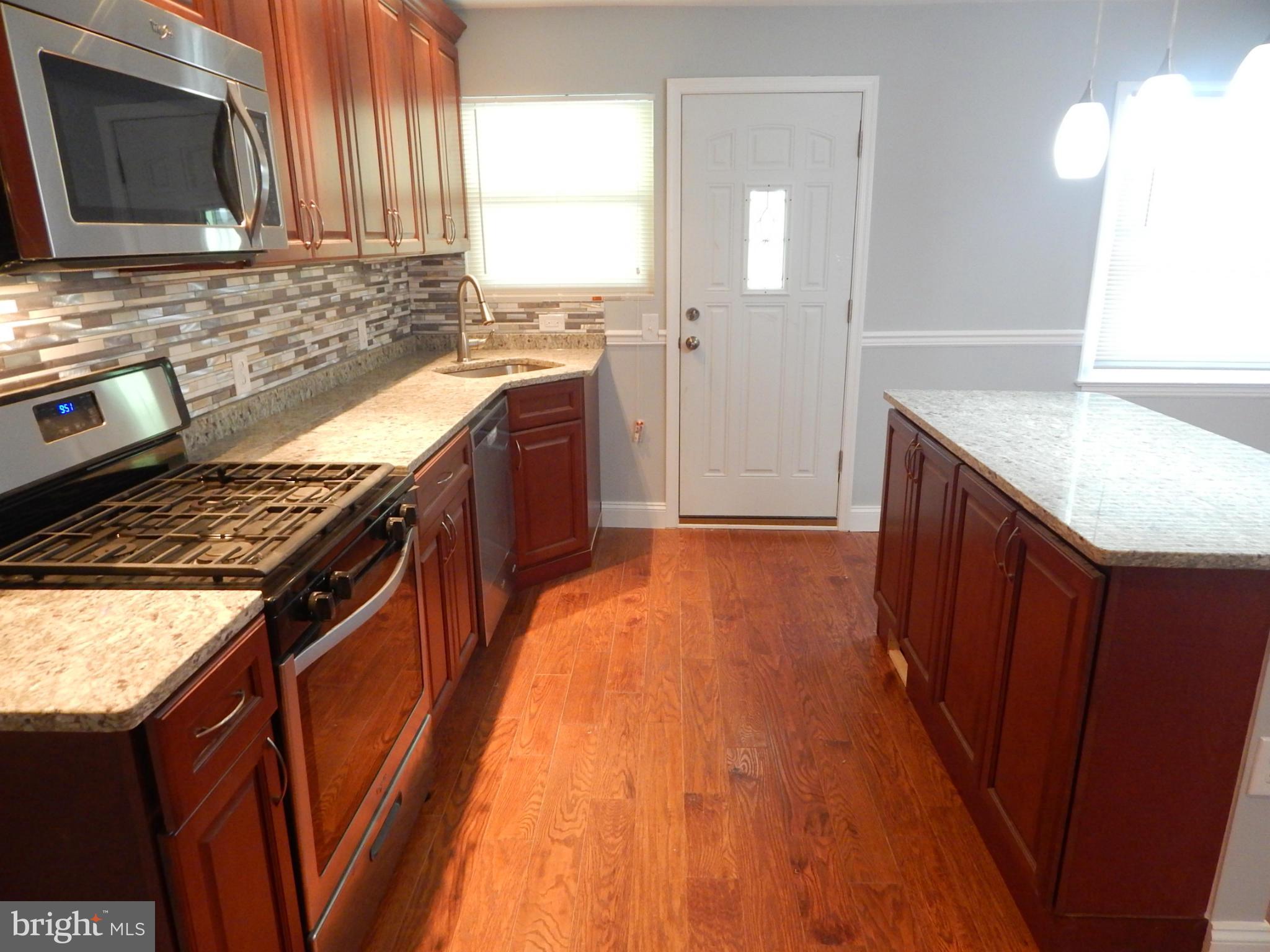 5618 Clearspring Road Baltimore, MD 21212 - Photo 12 of 30 a kitchen with stainless steel appliances granite countertop a stove a sink and a microwave