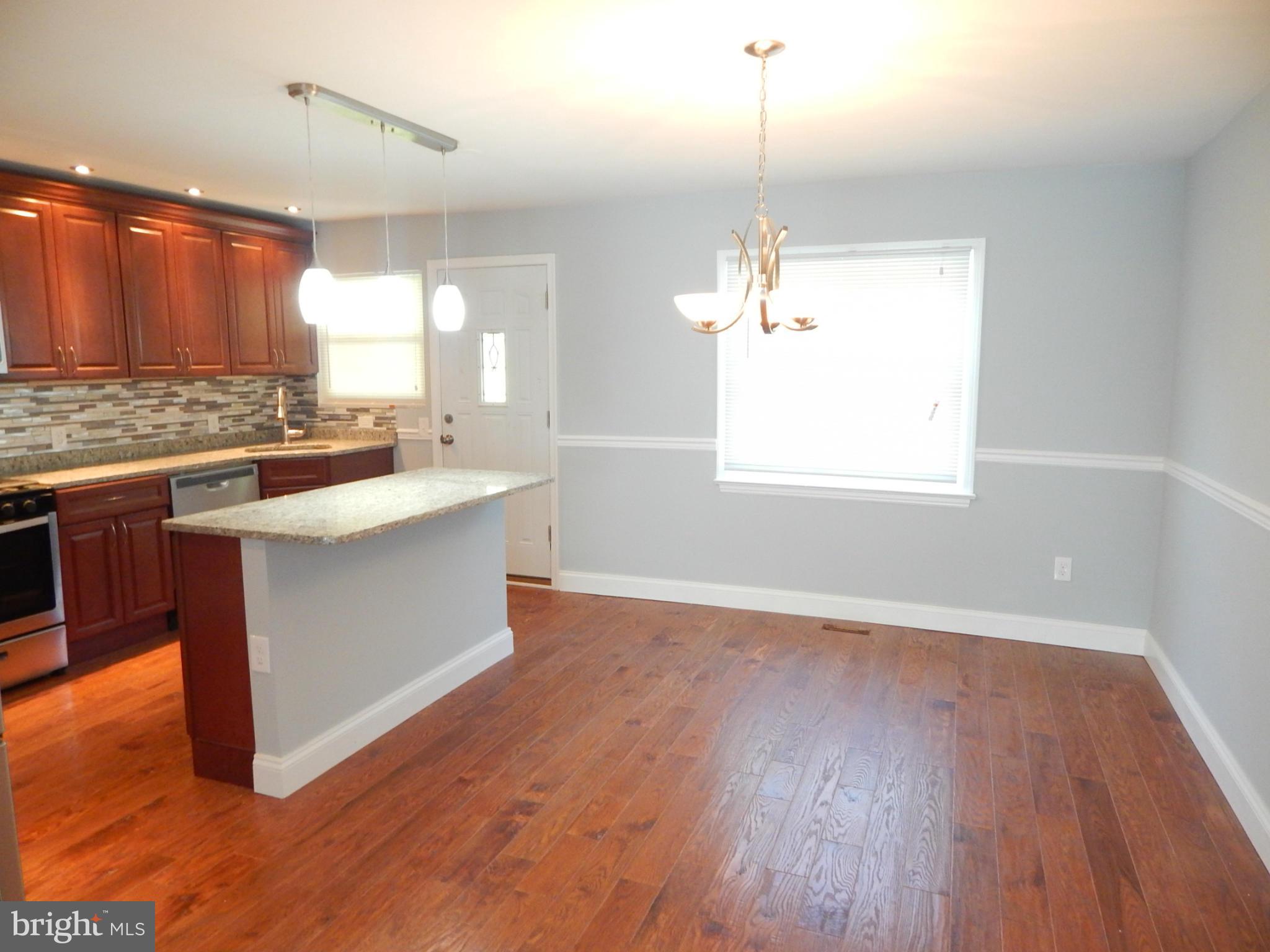5618 Clearspring Road Baltimore, MD 21212 - Photo 15 of 30 a kitchen with a sink stove and wooden floor