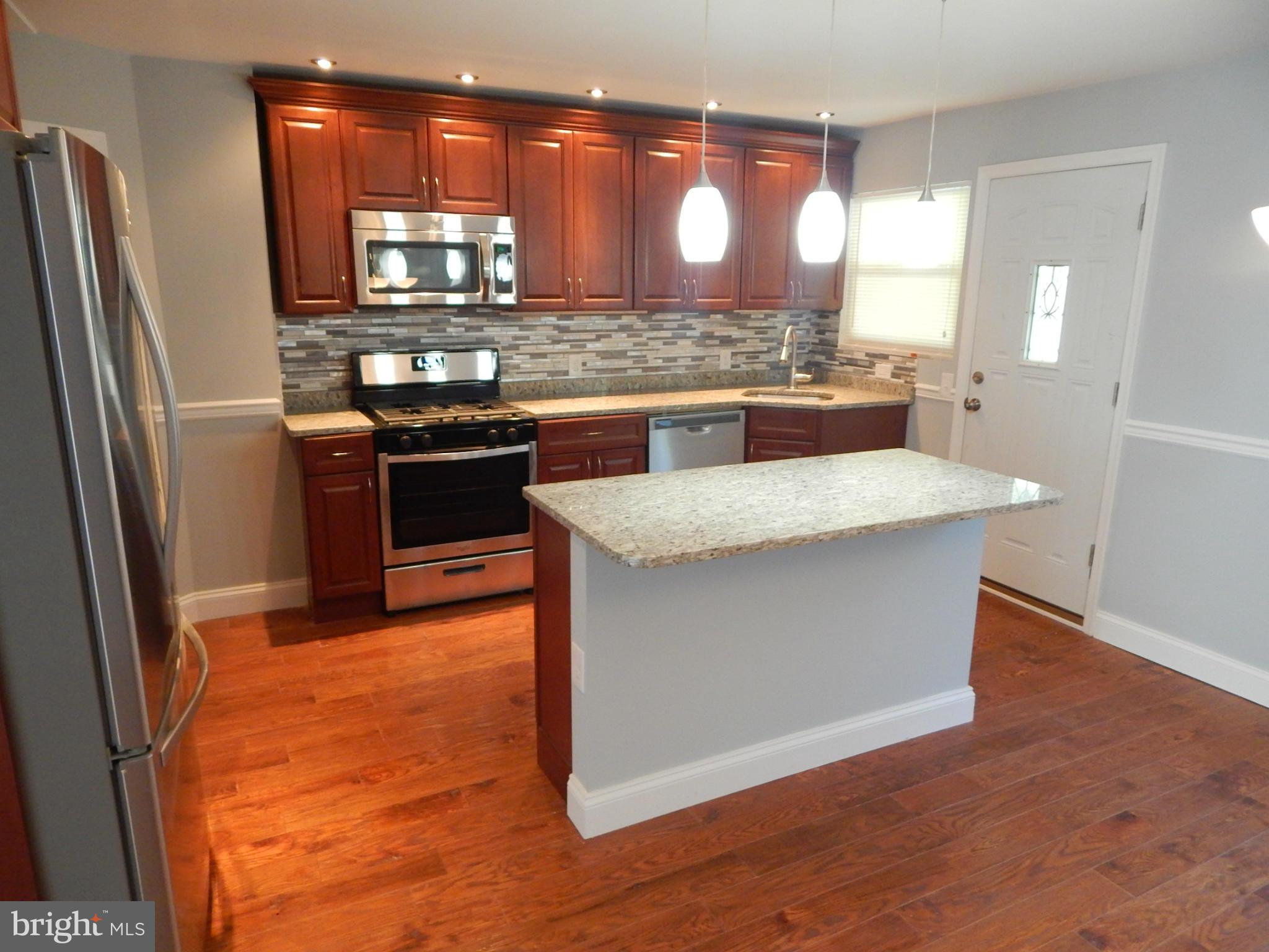 5618 Clearspring Road Baltimore, MD 21212 - Photo 3 of 30 a kitchen with stainless steel appliances granite countertop wooden cabinets and a granite counter tops