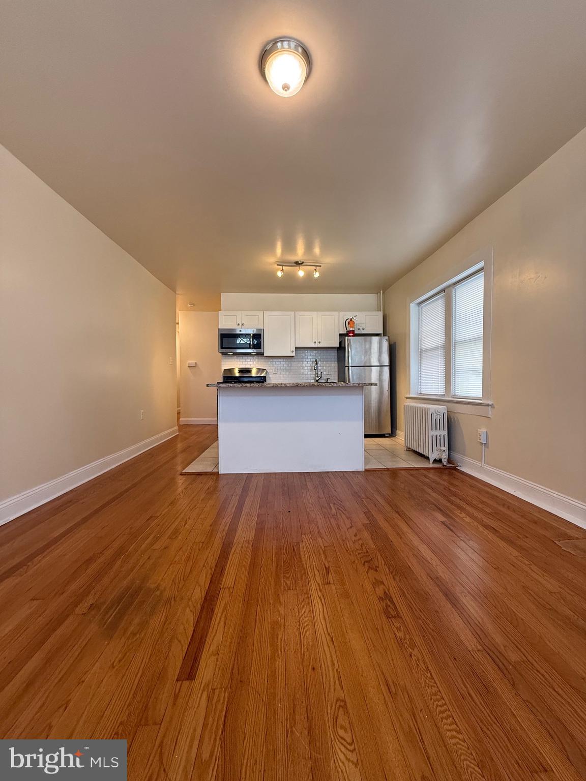 2250 Bryn Mawr Avenue, Unit 1C Philadelphia, PA 19131 - Photo 4 of 12 an empty room with wooden floor and windows