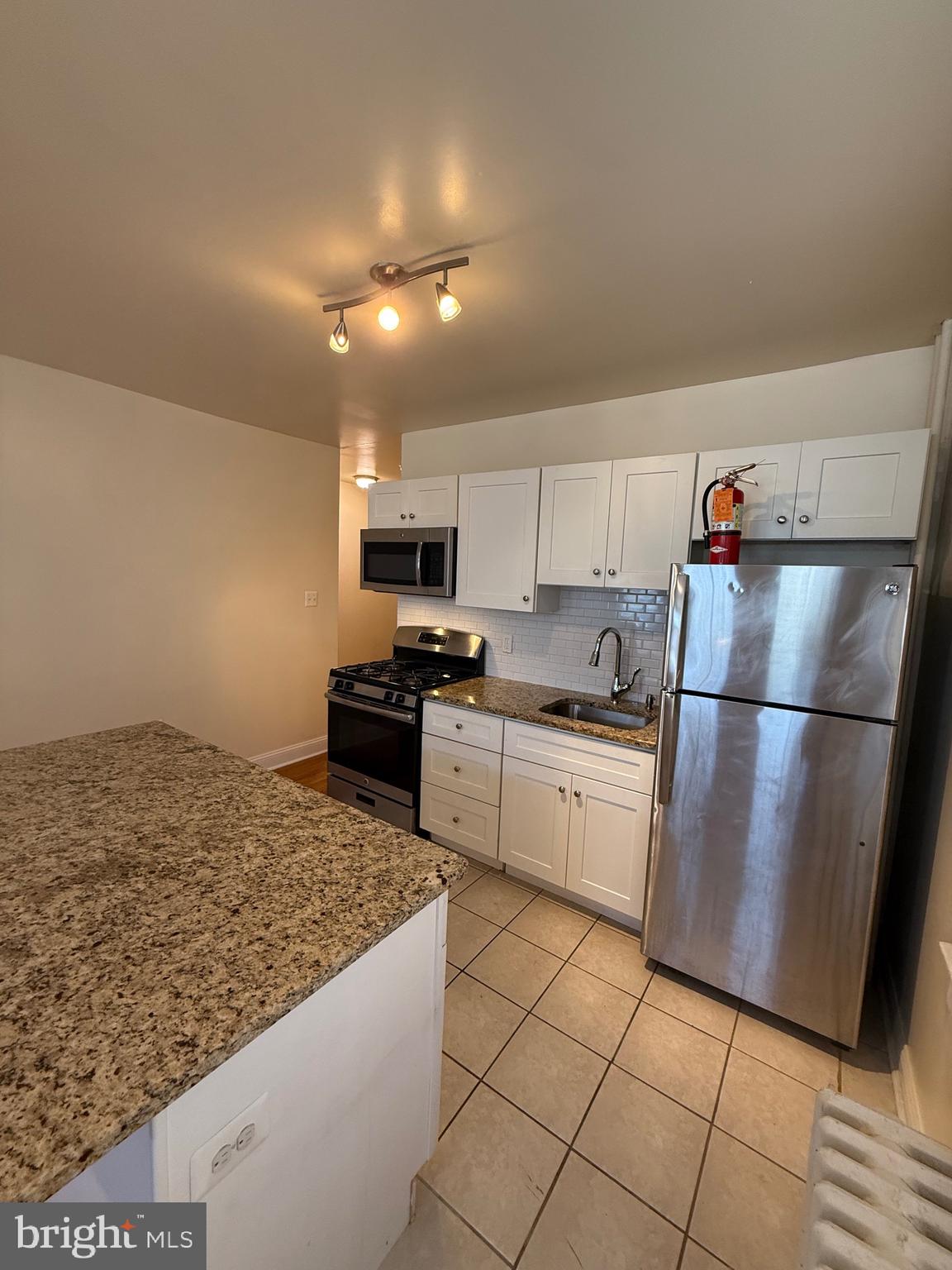 2250 Bryn Mawr Avenue, Unit 1C Philadelphia, PA 19131 - Photo 5 of 12 a kitchen with a sink stainless steel appliances and cabinets