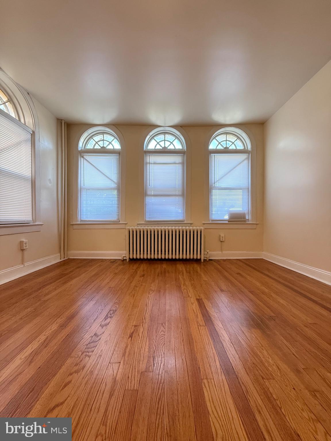 2250 Bryn Mawr Avenue, Unit 1C Philadelphia, PA 19131 - Photo 6 of 12 an empty room with wooden floor and windows