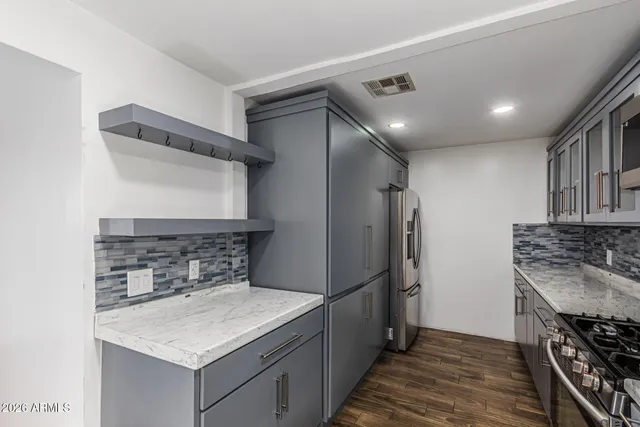 a kitchen with stainless steel appliances granite countertop a sink stove and refrigerator