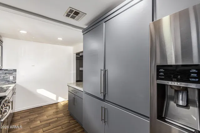 a kitchen with metallic refrigerator and black appliances