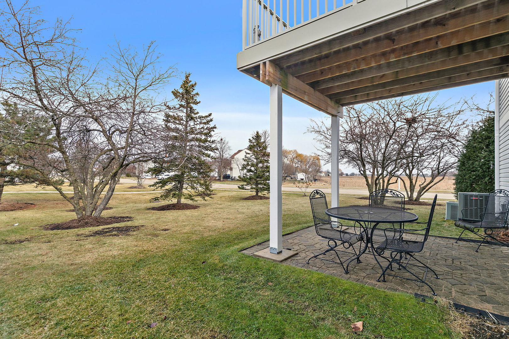 2350 Camden Bay, Unit 2350 Elgin, IL 60123 - Photo 19 of 20 a view of a backyard with table and chairs and a barbeque with potted plants and large trees