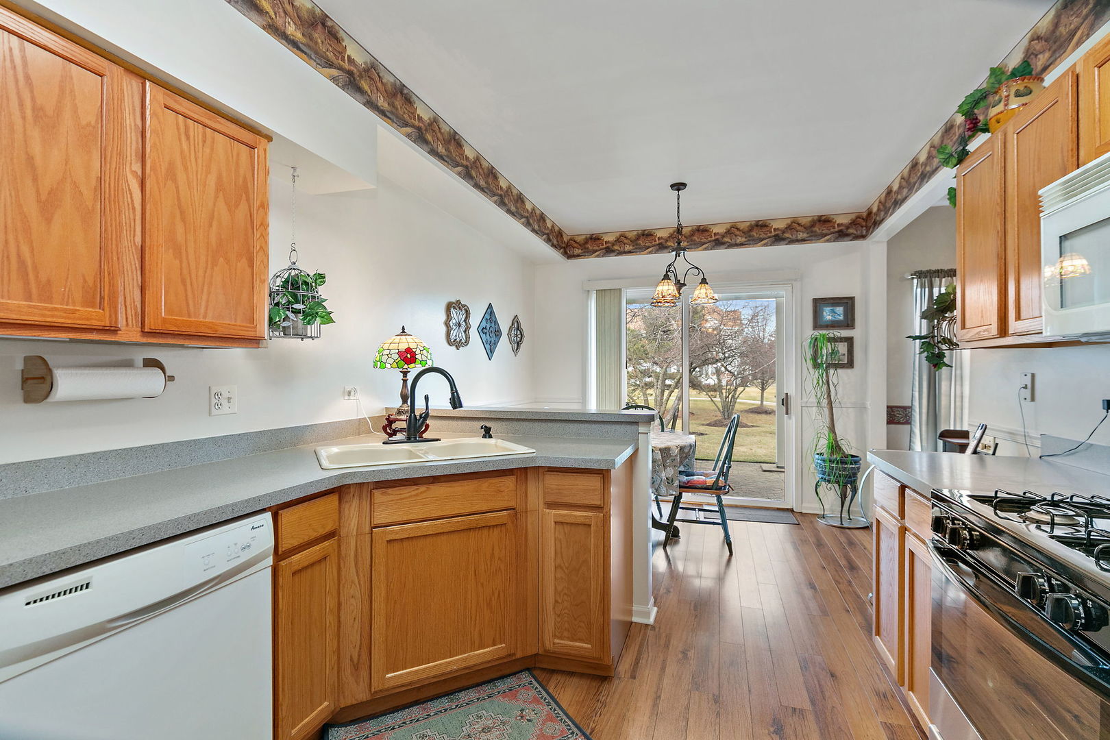 2350 Camden Bay, Unit 2350 Elgin, IL 60123 - Photo 7 of 20 a kitchen with a sink stove and wooden cabinets