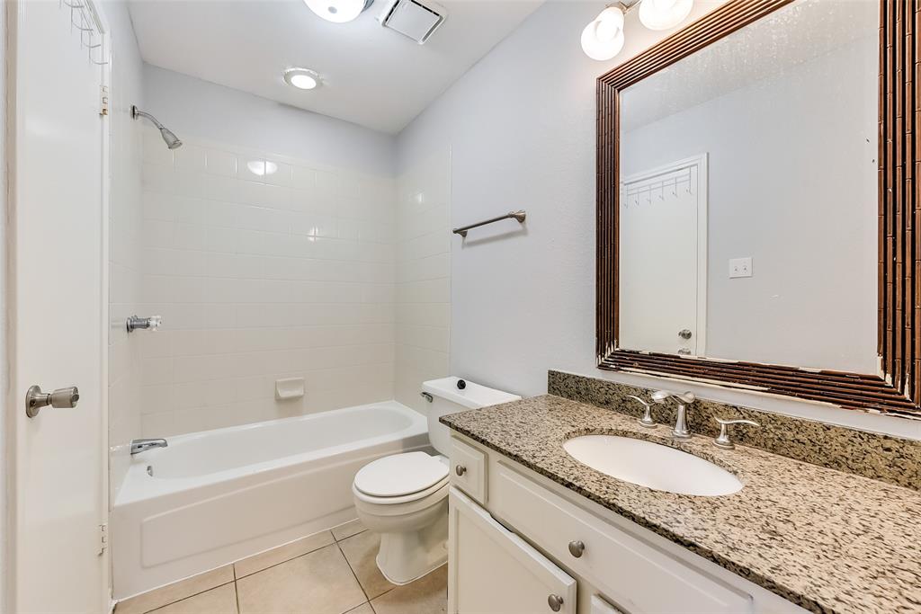 509 Parkway Boulevard Coppell, TX 75019 - Photo 11 of 19 a bathroom with a granite countertop sink a toilet and a large mirror