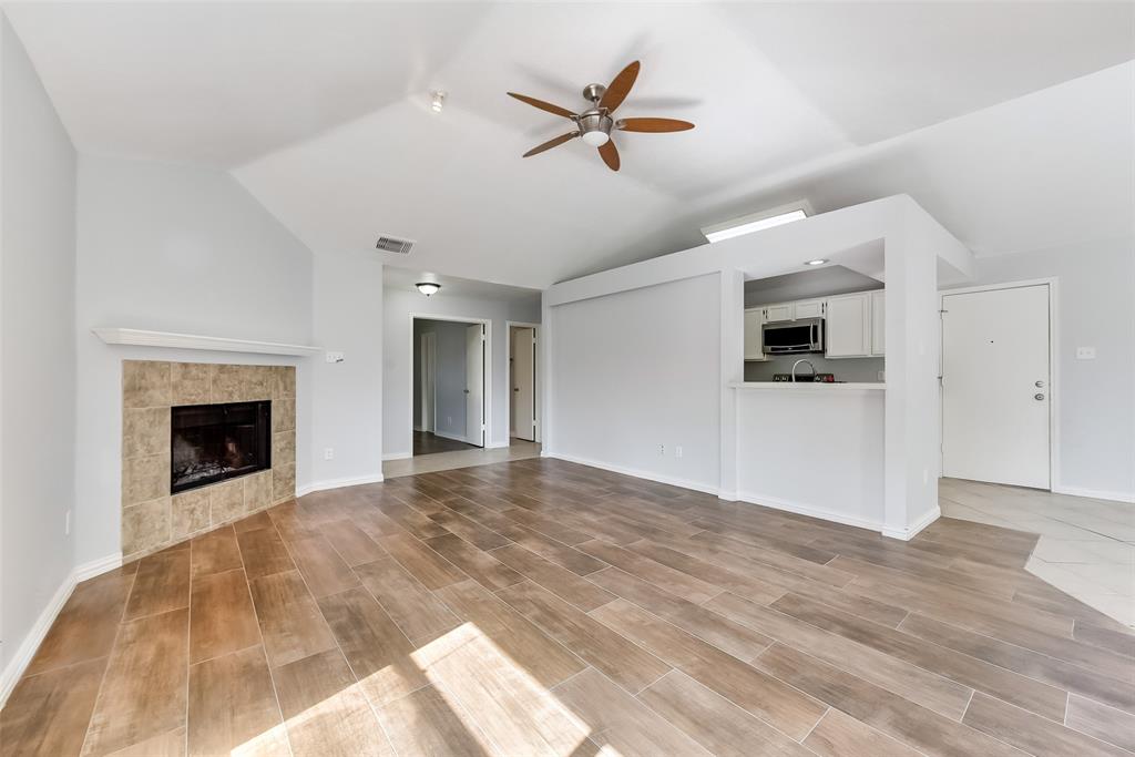 509 Parkway Boulevard Coppell, TX 75019 - Photo 5 of 19 a view of a livingroom with a fireplace a ceiling fan a kitchen stove and a fireplace