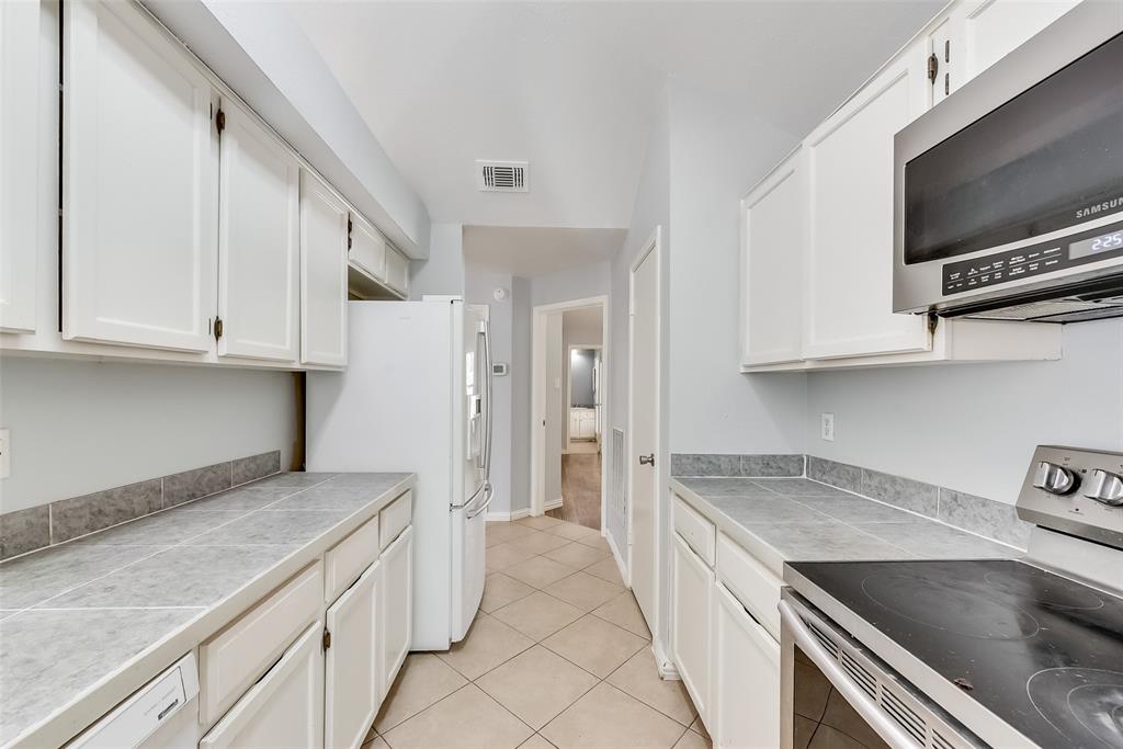 509 Parkway Boulevard Coppell, TX 75019 - Photo 7 of 19 a kitchen that has a sink and a stove in it