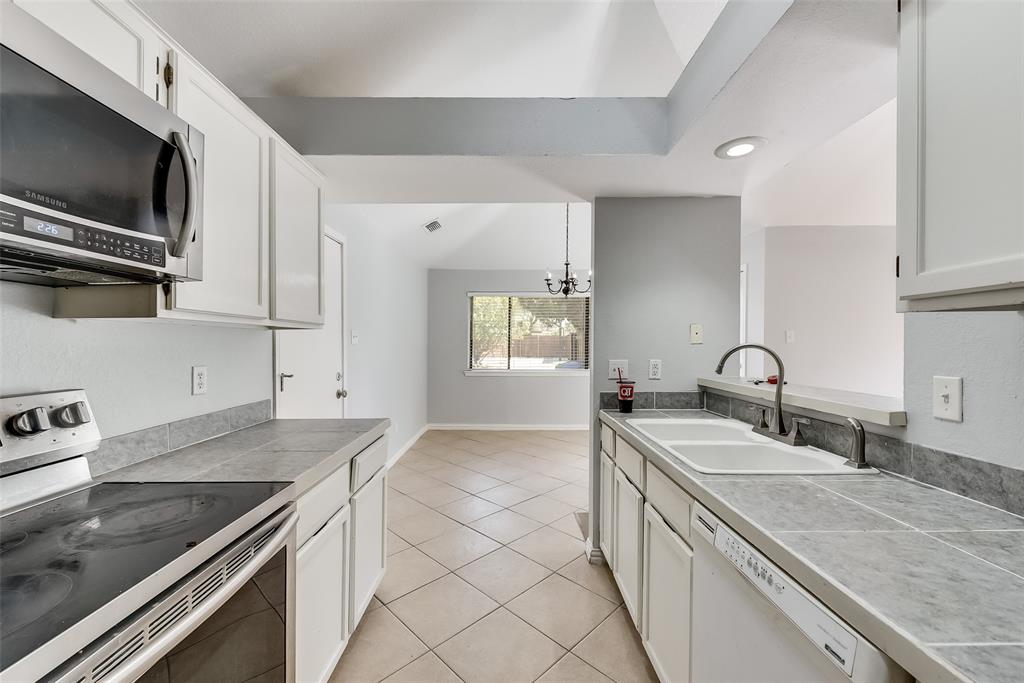 509 Parkway Boulevard Coppell, TX 75019 - Photo 8 of 19 a kitchen with stainless steel appliances granite countertop a sink and a stove