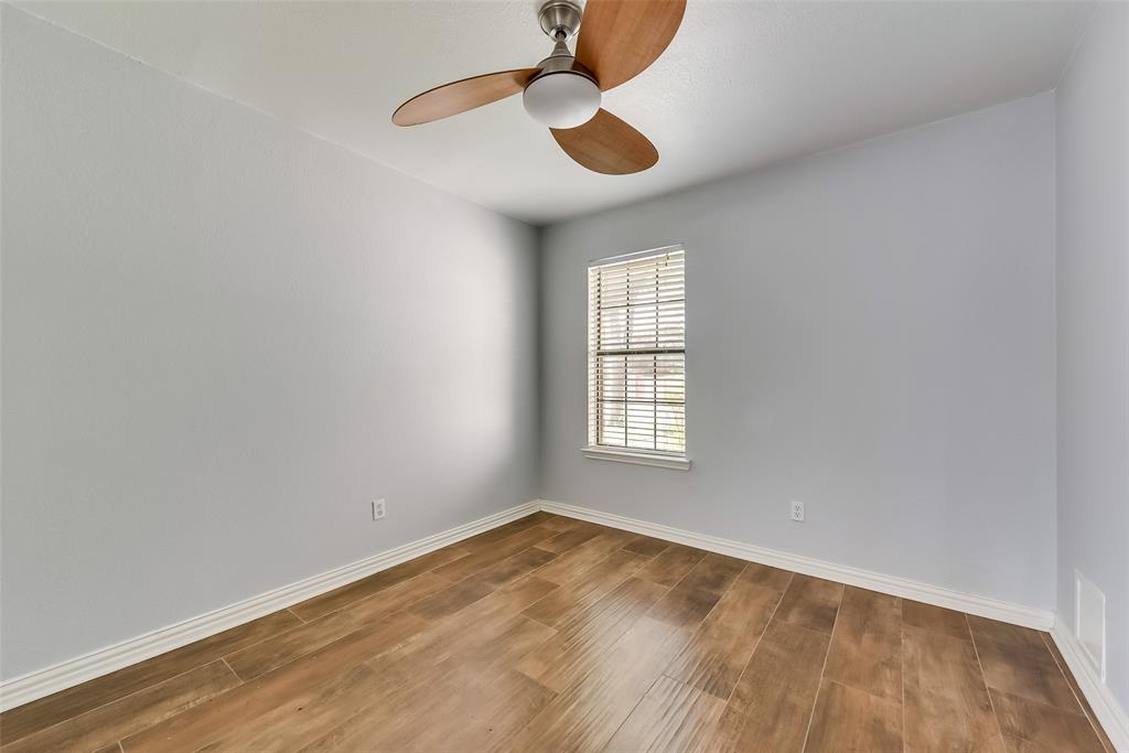 509 Parkway Boulevard Coppell, TX 75019 - Photo 9 of 19 an empty room with wooden floor and windows