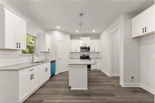 a large kitchen with stainless steel appliances lots of counter space and wooden floor
