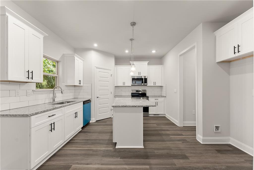 490 Magnolia Grove Place Cornelia, GA 30531 - Photo 14 of 43 a large kitchen with stainless steel appliances lots of counter space and wooden floor
