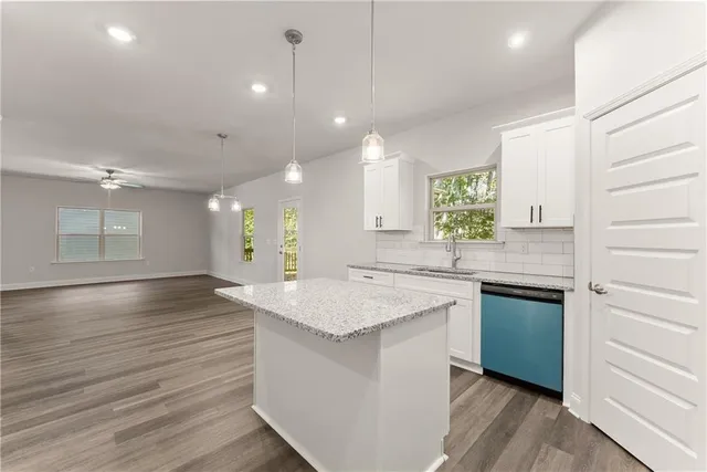 a kitchen with granite countertop white cabinets and white appliances