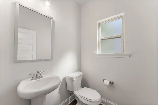 a white toilet sitting next to a bathroom sink
