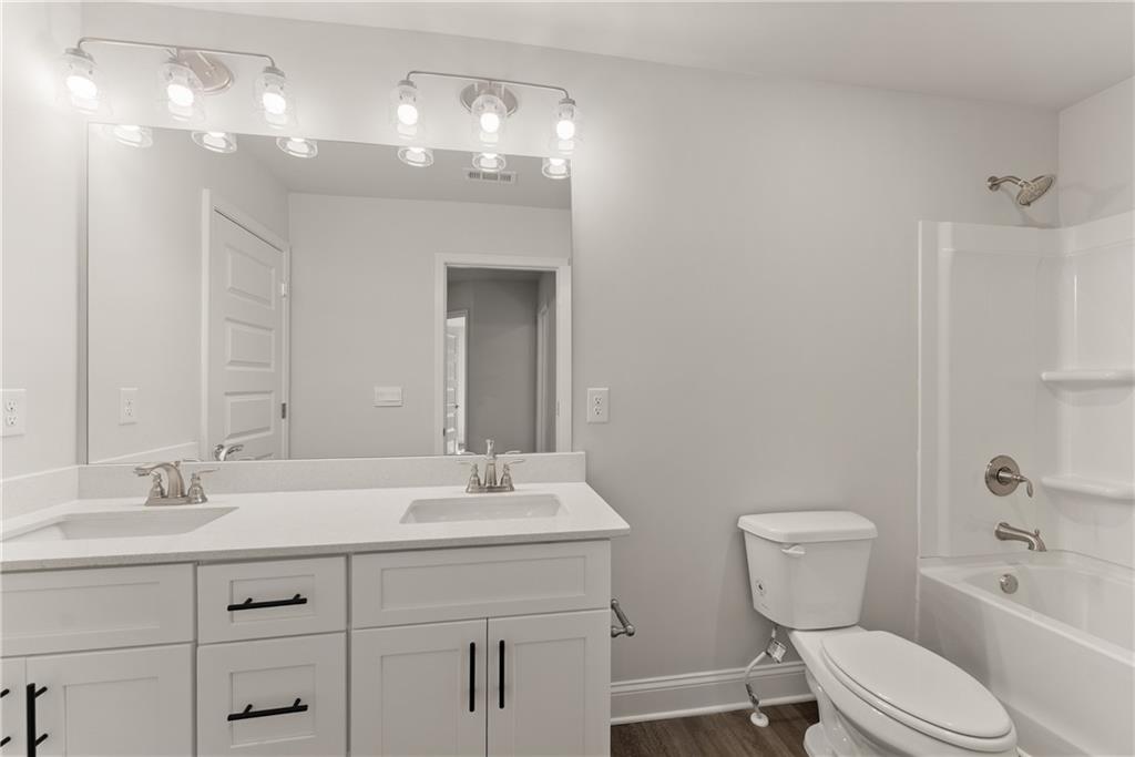 490 Magnolia Grove Place Cornelia, GA 30531 - Photo 24 of 43 a bathroom with a toilet a sink a tub and mirror