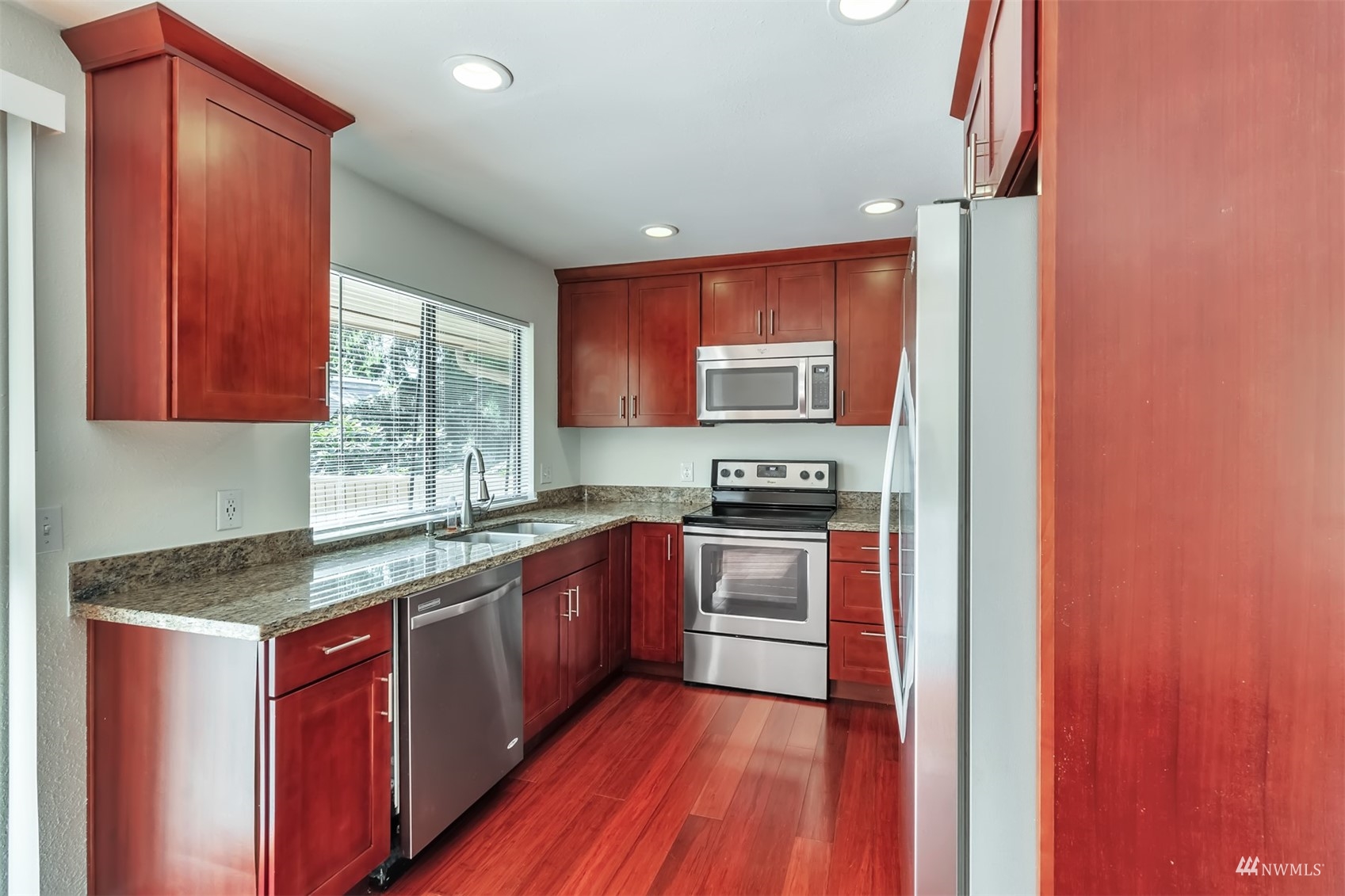 11201 3rd Avenue Southeast, Unit 1B Everett, WA 98208 - Photo 3 of 15 a kitchen with stainless steel appliances granite countertop wooden cabinets a stove top oven a sink and dishwasher