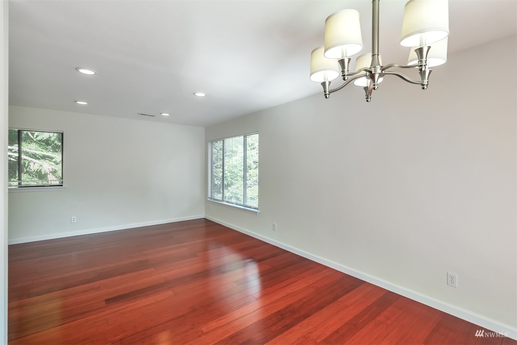 11201 3rd Avenue Southeast, Unit 1B Everett, WA 98208 - Photo 4 of 15 an empty room with wooden floor fan and windows