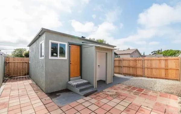 a view of a house with backyard and wooden fence