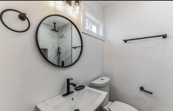 a bathroom with a toilet sink and mirror