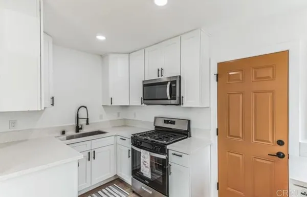 a kitchen with stainless steel appliances granite countertop a sink stove and microwave