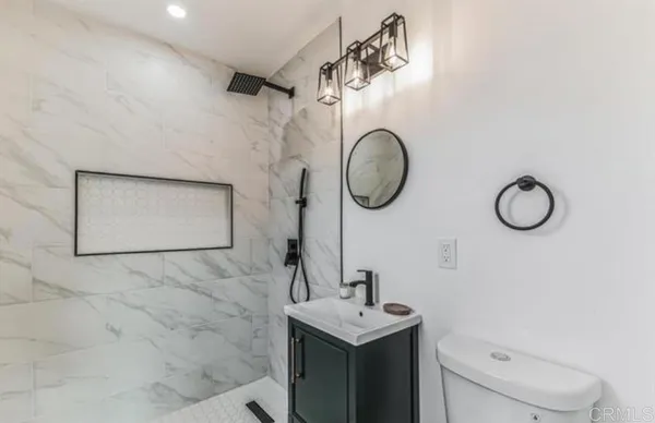 a bathroom with a toilet sink and mirror