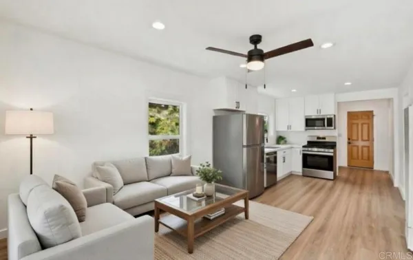 a living room with furniture a couch and a ceiling fan