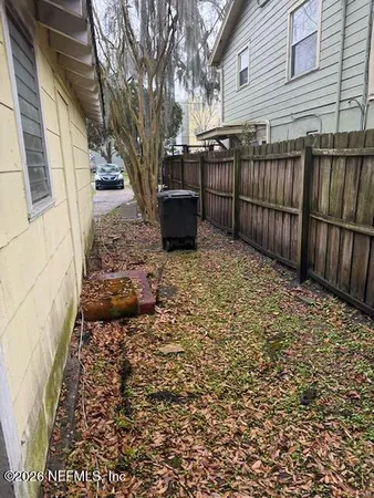 a view of a yard with wooden fence