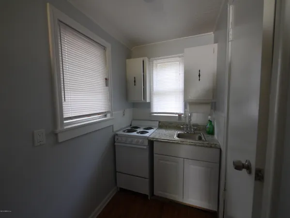 a room with a sink cabinets and a window