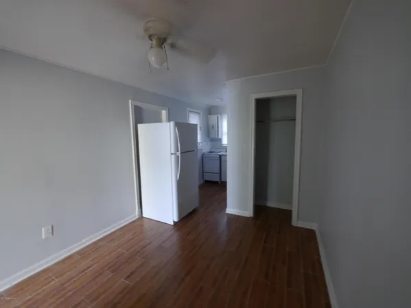 a view of a room with wooden floor and a ceiling fan