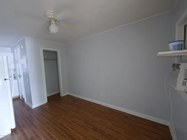 a view of an empty room with wooden floor