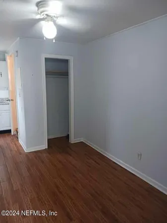a view of an empty room with wooden floor